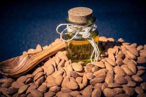 a pile of almonds and a glas with almond oil photo