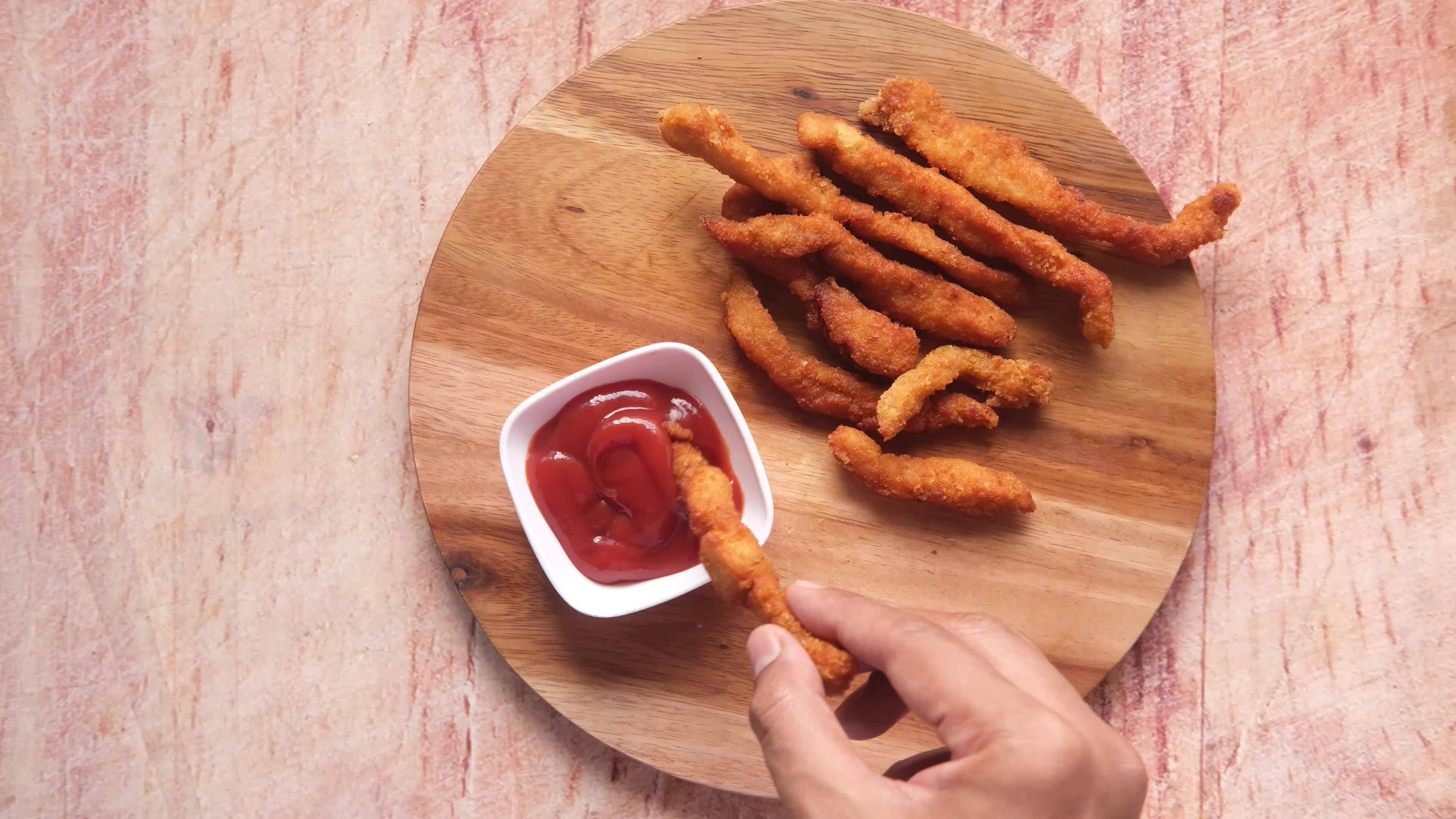 Dipping chicken fingers in ketchup 14005857 Stock Video at Vecteezy