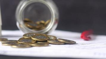 Savings jar flipped over, coins close up video