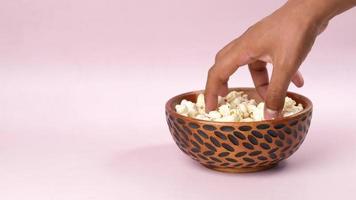 Grabbing popcorn from a small bowl video