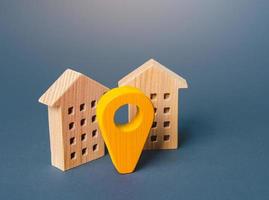 Yellow geo location pin and two houses. Tracking, city navigation internet of things. Location concept, settlement. Search for housing options. Infrastructure and surroundings. Local searching. photo