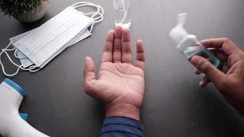 applicering hand desinfektionsmedel på tabell med masker och spray flaska video