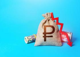 Russian ruble money bag and arrow down. Falling economy. Decrease in interest rate deposit rate. Inflation. Low real incomes, economic difficulties. Unprofitability, recession and depression. photo