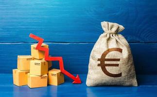 bolsa de dinero en euros con cajas y flecha hacia abajo. disminución de ingresos, desaceleración y declive de la economía. ventas bajas disminución de la producción. precios de transporte reducidos. mal sentimiento del consumidor y demanda de bienes. foto