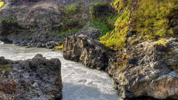 video hd de un río fluyendo a través de un desfiladero, con montañas al fondo... filmado en islandia. vídeo de alta definición, hdr