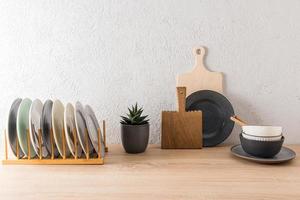 kitchen background in minimalist style. table top with several cutting boards, plates, bowls, flower in a pot. photo
