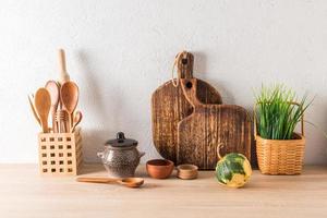 el concepto de decoración de la cocina casera en una casa de campo, casa de campo. utensilios de madera, platos de loza y cerámica, planta en cesta. cero desperdicio. foto