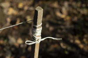 Rope on stick. Ground marking. Rope wound on board. Earth measurement by filament. photo