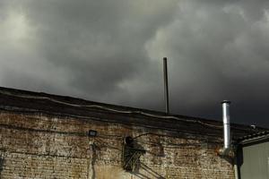 Roof of building with pipe. Brick house. Industrial Building Details. photo