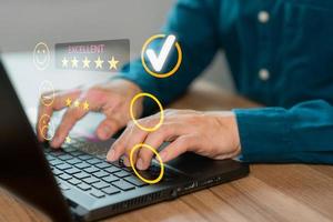 Man hand using computer laptop with popup five star icon for feedback review satisfaction service, testimonial. Customer service experience and business satisfaction survey. photo