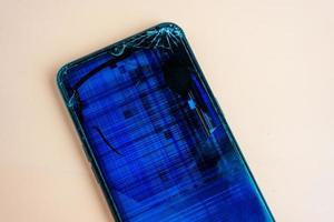 The broken screen of a smartphone with numerous cracks photo