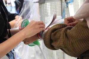 Woman putting a paper bracelet ticket photo