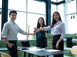 businessman businesswoman male female smart fashion young adult beautiful look at camera touch hand symbol business teamwork colleague group corporate partner office company success concept photo