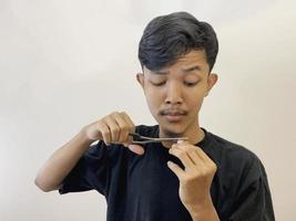 man cutting his own beard using scissors by himself photo