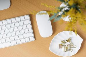 Home office with a computer, a bouquet of mimosa flowers in a vase. photo