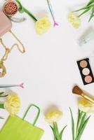 Flat lay, top view table desk frame. Feminine blogger desk workspace with cosmetics, lipstick and tulip flowers on white background. photo