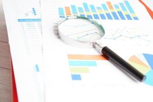 Magnifying glass on charts graphs paper. Financial development, Banking Account, Statistics, Investment Analytic research data economy. photo
