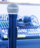 micrófono en trípode con fondo de mezclador en la sala de control de sonido. foto