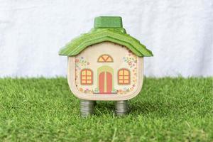 Mock up house on coins stack and grass floor photo