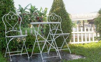 rincón de jardín con juego de mesa y silla de metal blanco foto