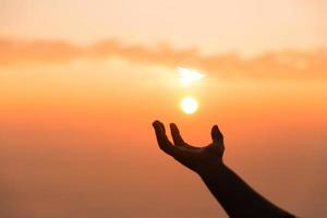 Silhouette of woman hand praying spirituality and religion, female worship to god. banner with copy space. Religious people are humble to God. Christians have hope faith and faith in god. photo