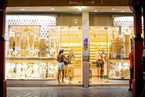 Dubai, UAE, 2022 - tourist enter gold shop in gold souk in old Dubai. Famous sightseeing attraction in Dubai, UAE photo