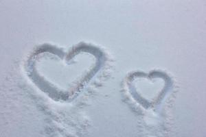 corazones grandes y pequeños dibujados en la nieve foto