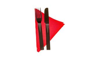 Fork and knife in a red napkin isolated on white background photo