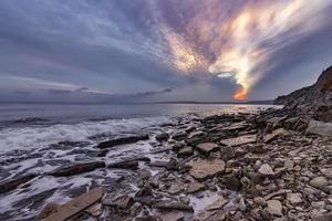 Exciting autumn sunset.Beauty sea rocky coast and cleavage sky photo