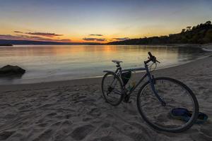 view of bicycle on the shore amid beautiful sunset photo