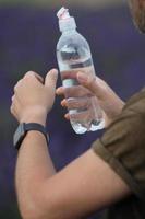 Hand holding a bottle of water photo