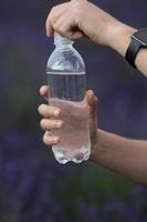 Hand holding a bottle of water photo