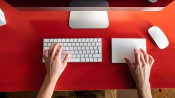 Female hands work with a keyboard and a touchpad, a mouse and a computer are nearby. Remote work. Contemporary workplace. photo