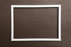 White rectangular blank frame on brown textured background. Copy space. Top view. photo