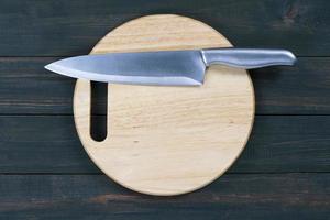 Close up kitchen knife on wooden round cutting board photo