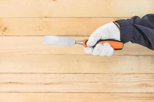 Hand in glove holding chisel photo