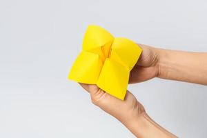 Hand in a paper fortune teller isolated on white background. photo