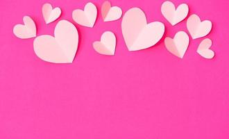 Shape of heart flying on pink paper background. photo