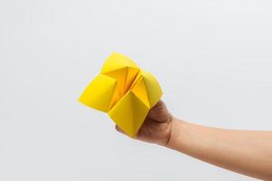 Hand in a paper fortune teller isolated on white background. photo