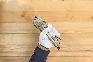 Hand in glove holding Adjustable wrench photo