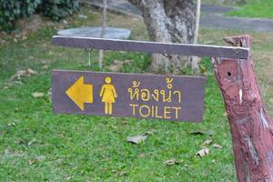 letrero de madera de ir al baño con idioma tailandés. foto