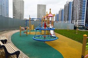 nuevo y moderno patio de recreo al aire libre al aire libre con equipo de ejercicio y juguetes en un nuevo distrito de la ciudad en el patio de un nuevo edificio foto