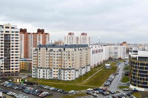 vista superior de una gran ciudad moderna con casas, edificios de varios pisos y arquitectura, estacionamiento y muchos autos