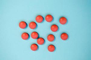 Red round medical pharmaceutical pharmaceuticals for the treatment of diseases pills medicines on a blue background photo