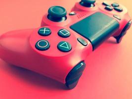 Beautiful red digital modern new game joystick for computer video games gamepad on a red background photo