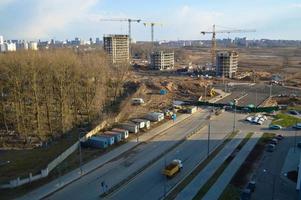 vista superior de un gran sitio de construcción con grúas y edificios que albergan rascacielos monolíticos de hormigón de varios pisos de la gran ciudad de la metrópolis foto