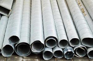 Large iron metal tin corrugated ventilation pipes of large diameter for the industrial construction of ventilation at a construction site during the repair photo