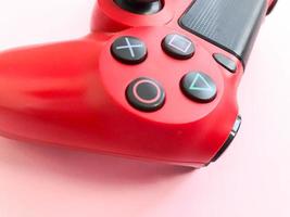 hermoso joystick de juego nuevo digital rojo moderno para videojuegos de computadora gamepad sobre un fondo rosa foto