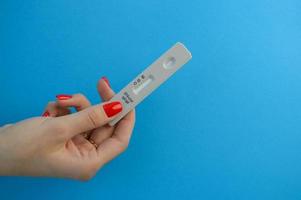 test system for diagnosing coronavirus. a fingerstick test to identify infection. the test is held in the hands of a girl with rkasny manicure. home blood test photo