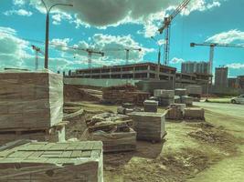 construcción de un centro comercial. construyendo paredes de bloques usando una grúa de construcción. en el sitio hay bloques debajo de la película foto